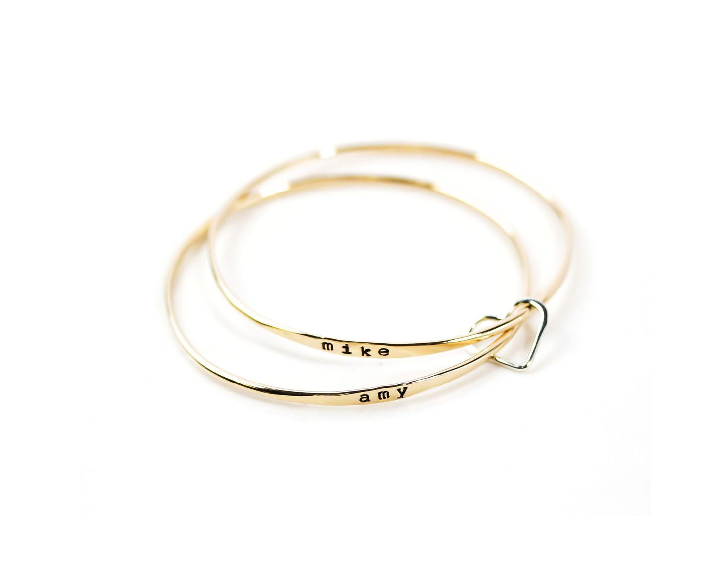A pair of gold-colored bracelets with the names 'Mike' and 'amy' engraved on them.