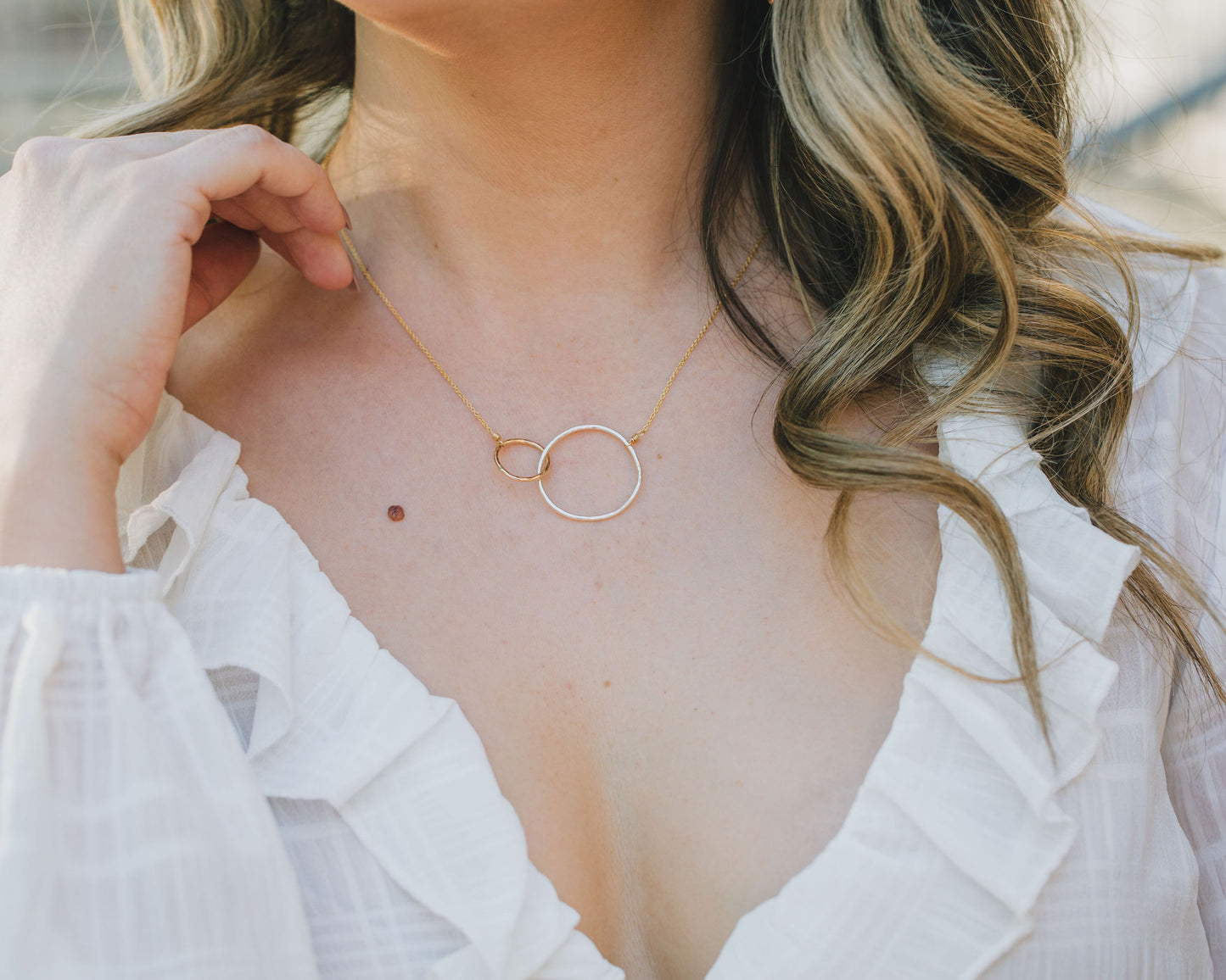 The larger circle measures approximately 1 inch across and is 925 Sterling Silver. The smaller circle measures approximately ½ inch across and is 14 karat Gold Filled. Our Barely There 1.1mm chain in 14 karat Gold Filled is expertly wire wrapped.