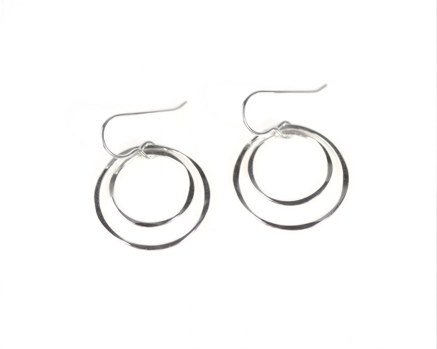 A pair of silver hoop earrings with a circular design, featuring two concentric circles connected by a thin metal hook.