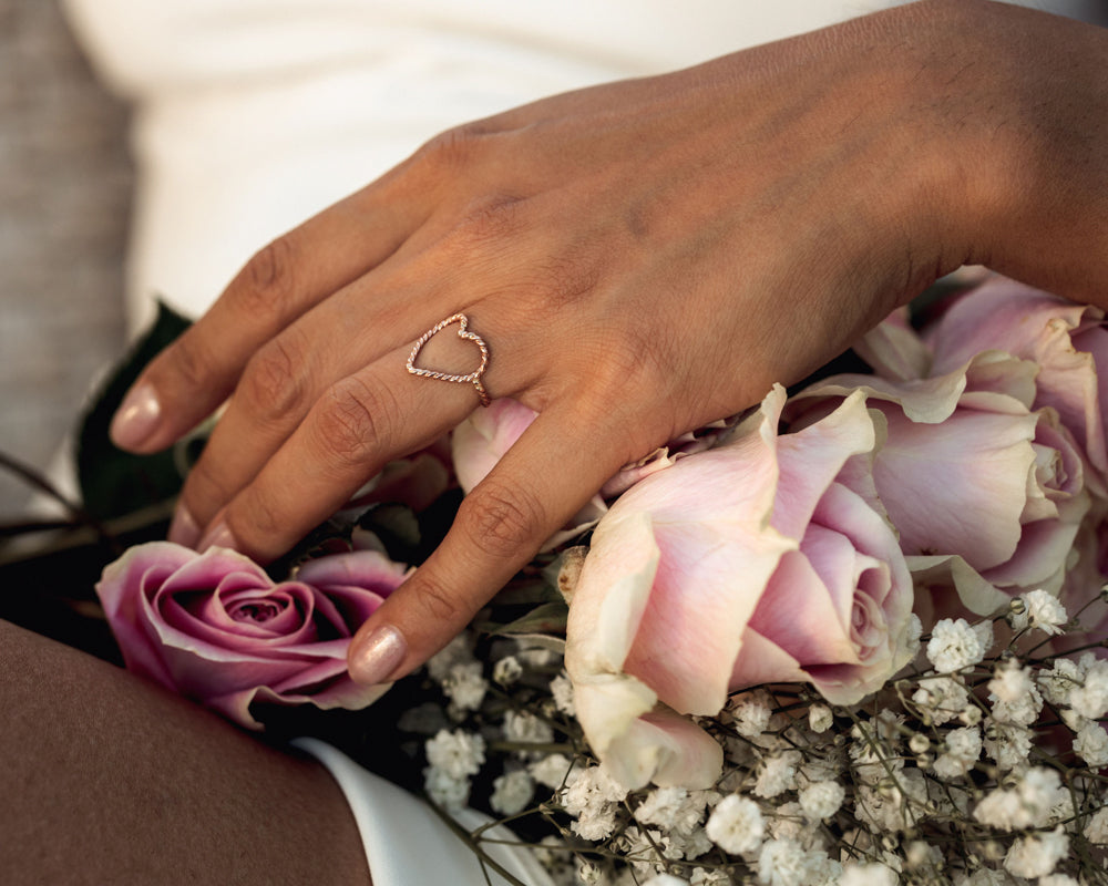 Close up image shows our twist open heart ring in 14 karat yellow gold filled. This heart ring is a simple, sweet and delicate reminder of love…with a twist! The open shape fits comfortably on the finger and makes a statement while wearing.