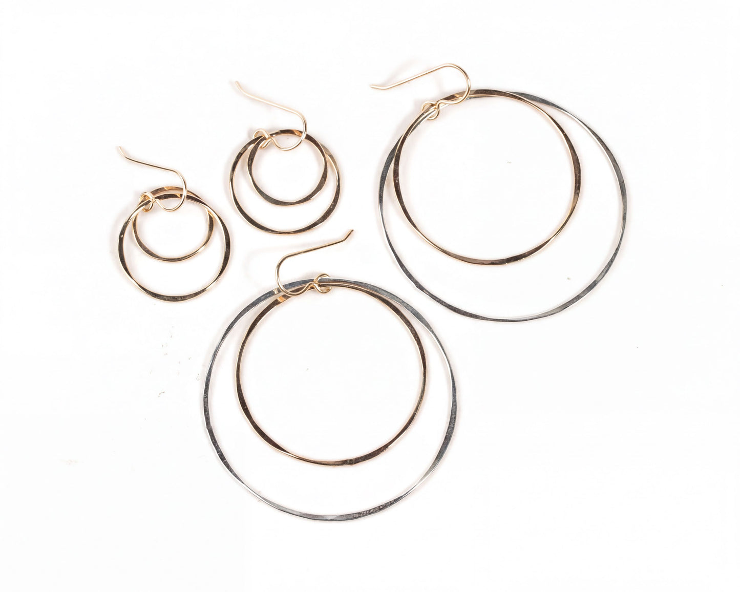 A pair of gold-toned hoop earrings with a unique design, featuring two overlapping circular hoops.