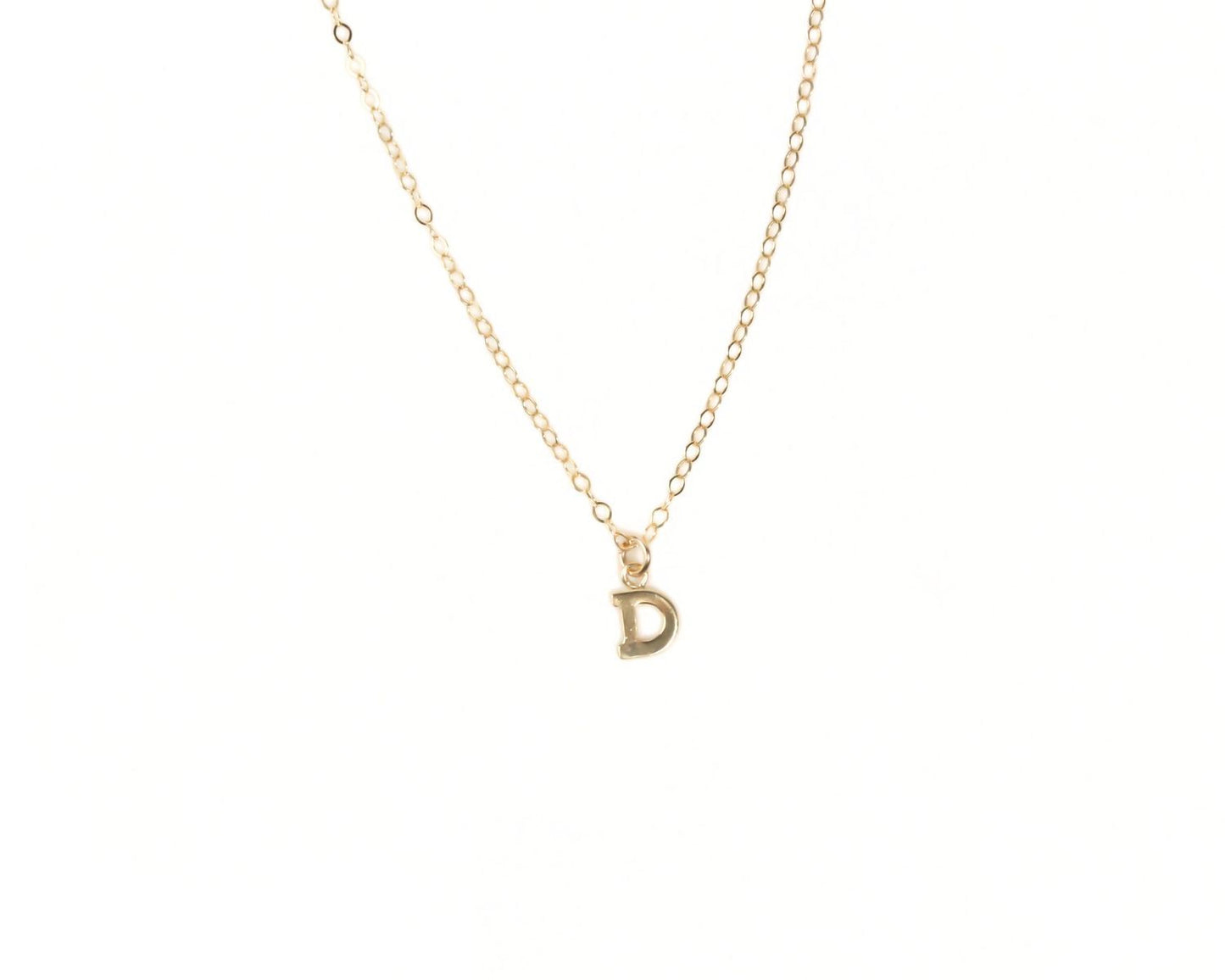 A delicate gold necklace with a single letter pendant.