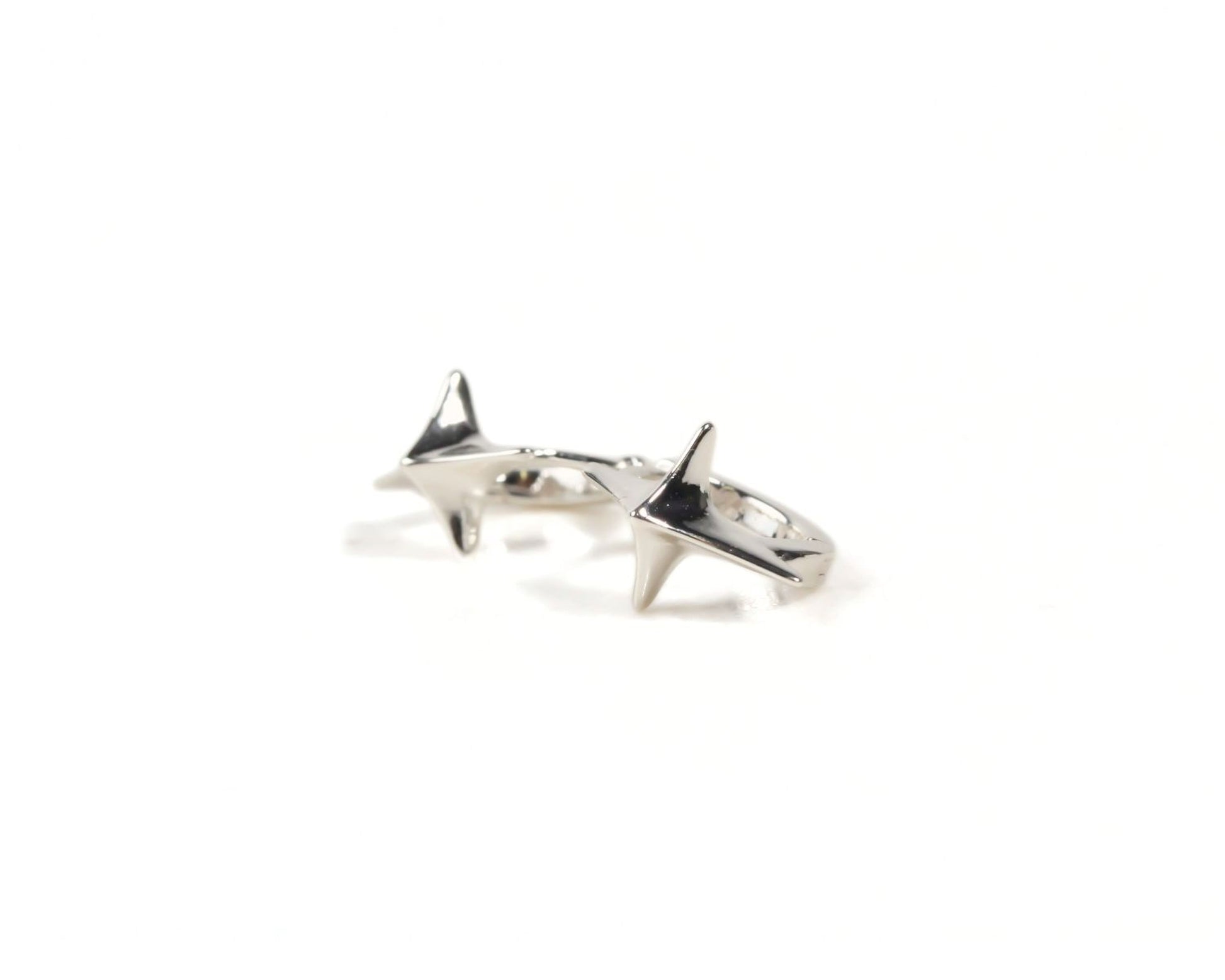 A pair of silver earrings with pointed shapes on a white background.