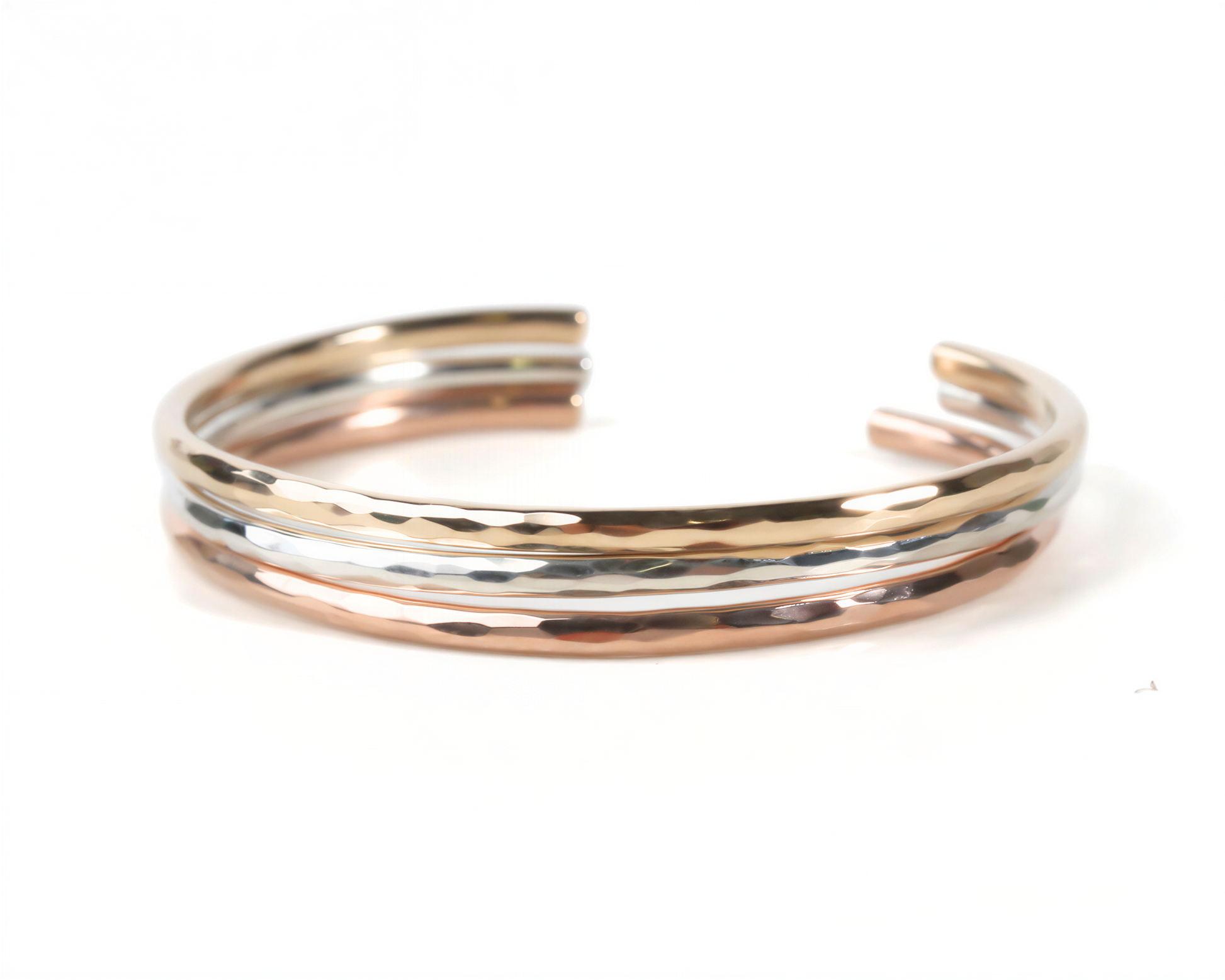 A bracelet made of three different colored metal, including gold, silver, and copper, arranged in a circular pattern.