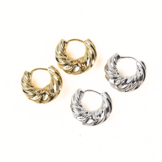 a pair of gold and silver earrings arranged on a white background.
