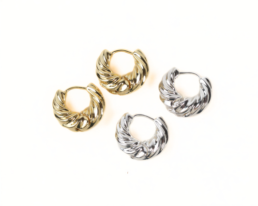a pair of gold and silver earrings arranged on a white background.