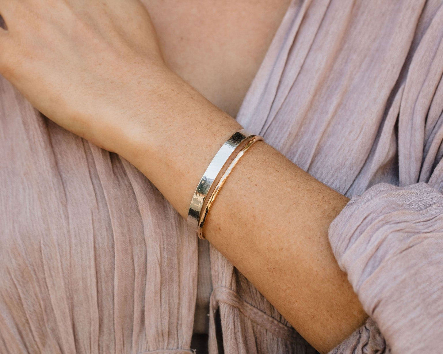 A close-up view of a person's arm wearing a silver bracelet.