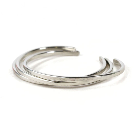 A silver bracelet with three curved links arranged in a circular pattern.