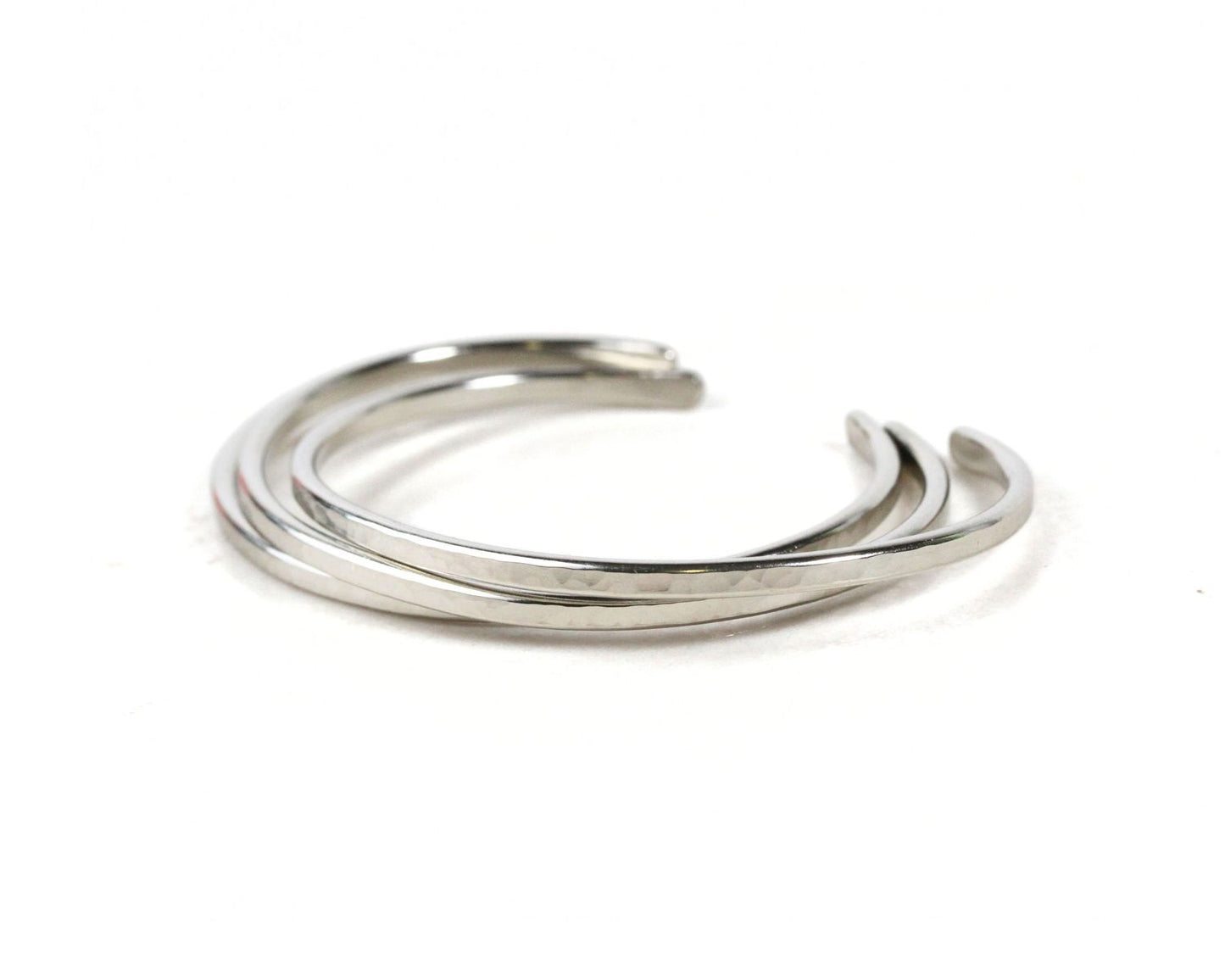 A silver bracelet with three curved links arranged in a circular pattern.