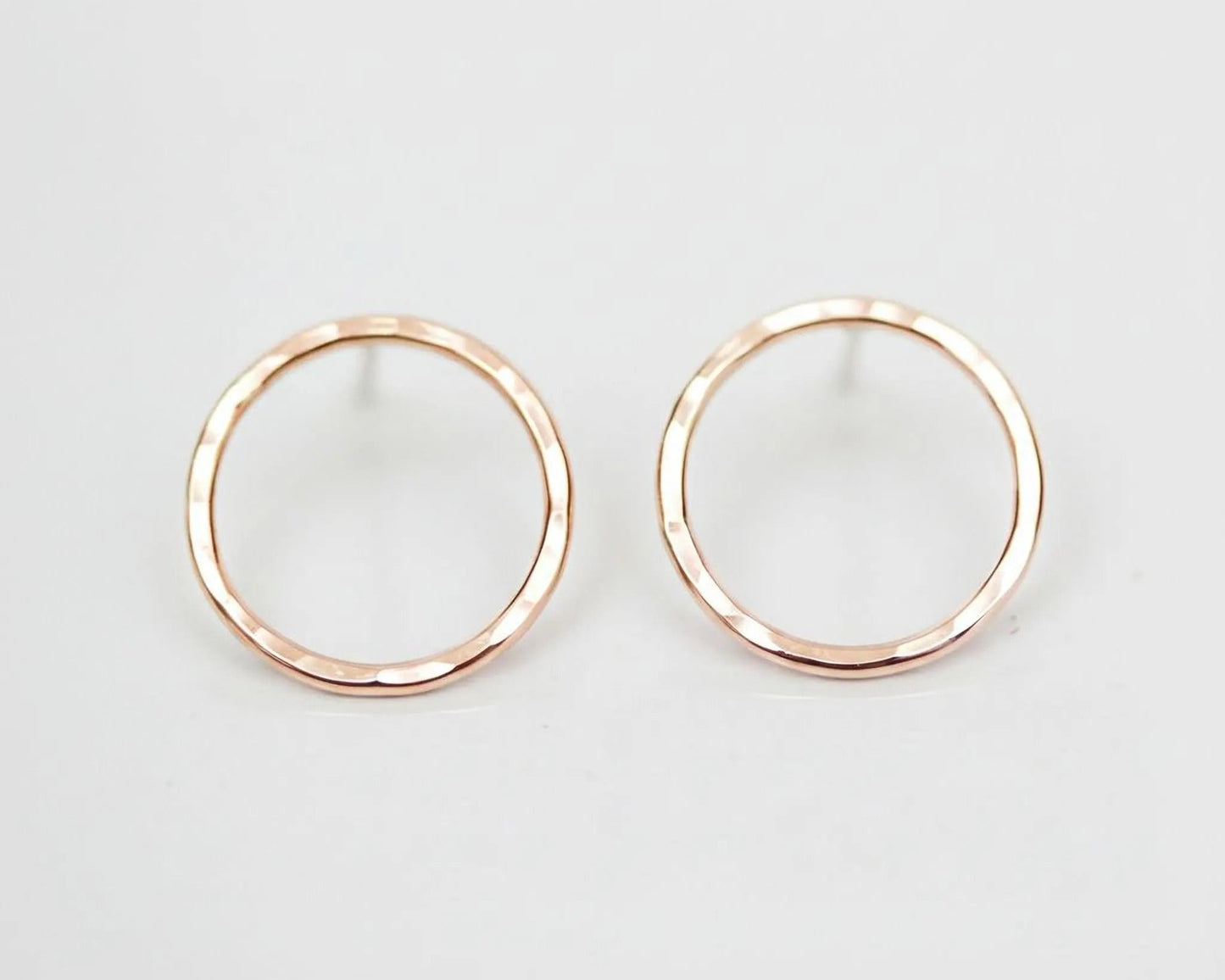 A pair of simple, elegant earrings with a round, metallic design.