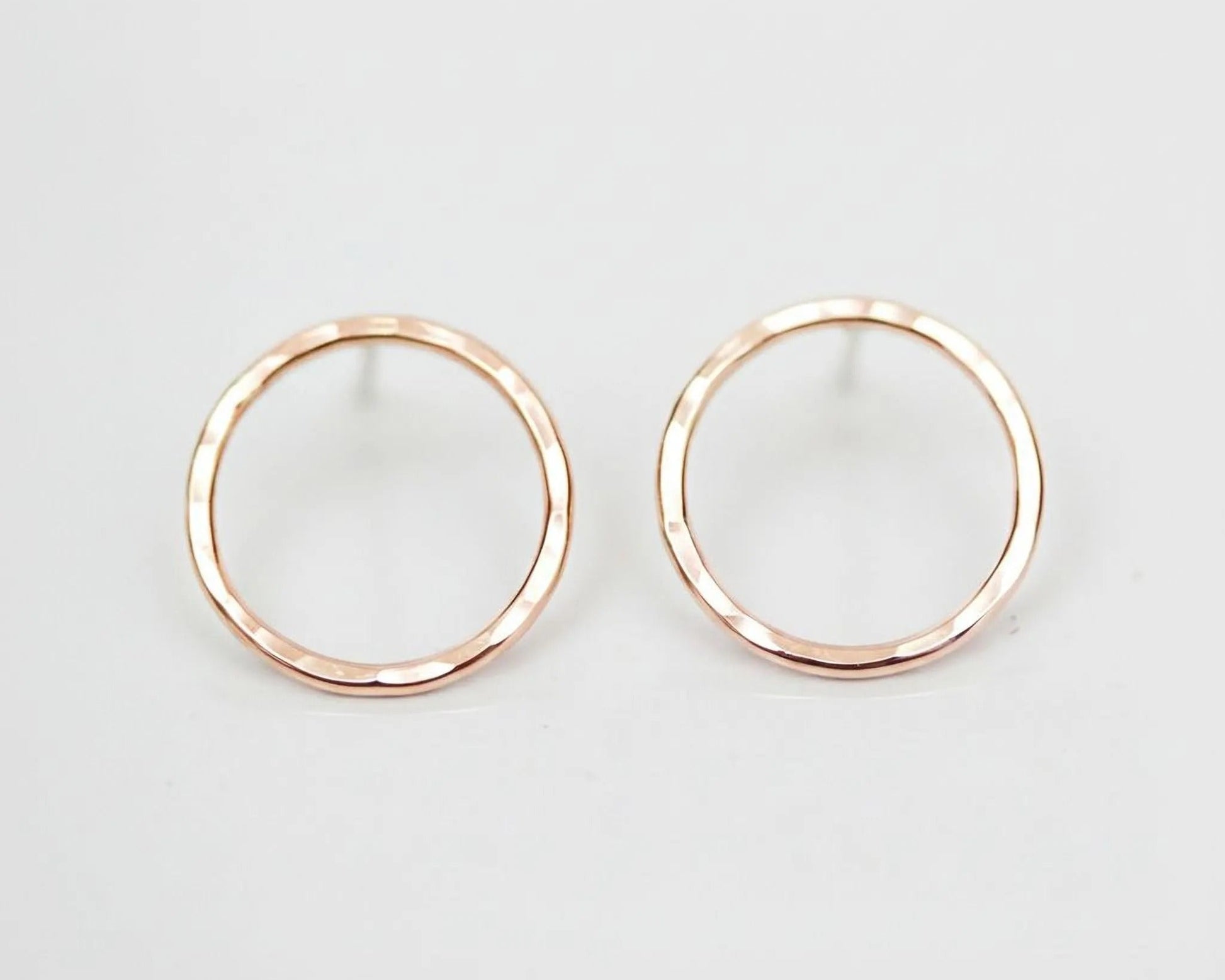 A pair of simple, elegant earrings with a round, metallic design.