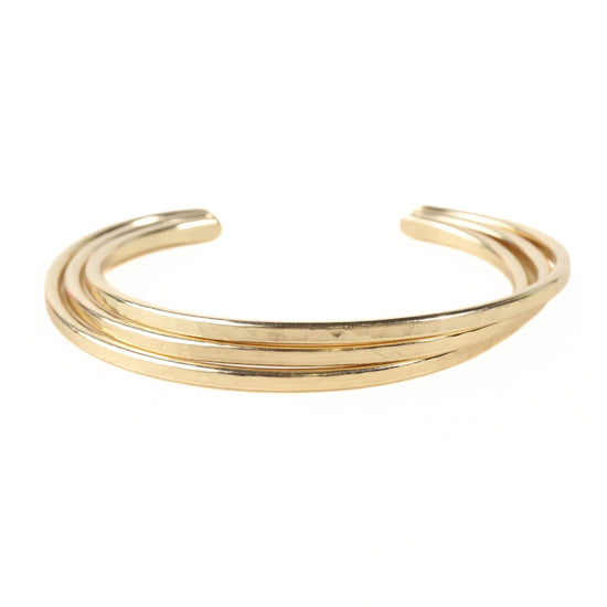 A gold-colored bracelet with three overlapping curved bands.