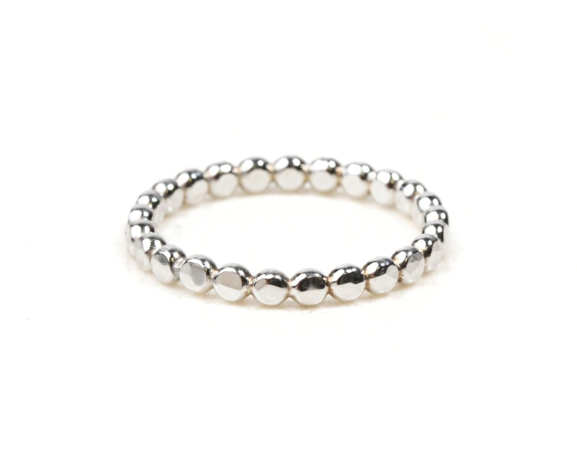 A silver ring with a row of small, round beads or stones arranged in a circular pattern.