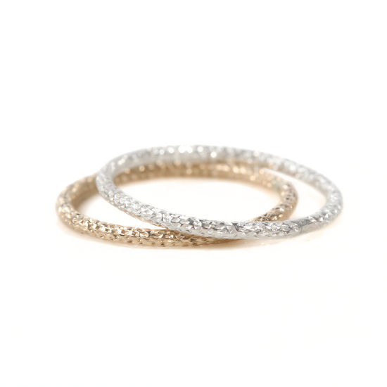 A pair of rings, one gold and one silver, are shown against a white background.