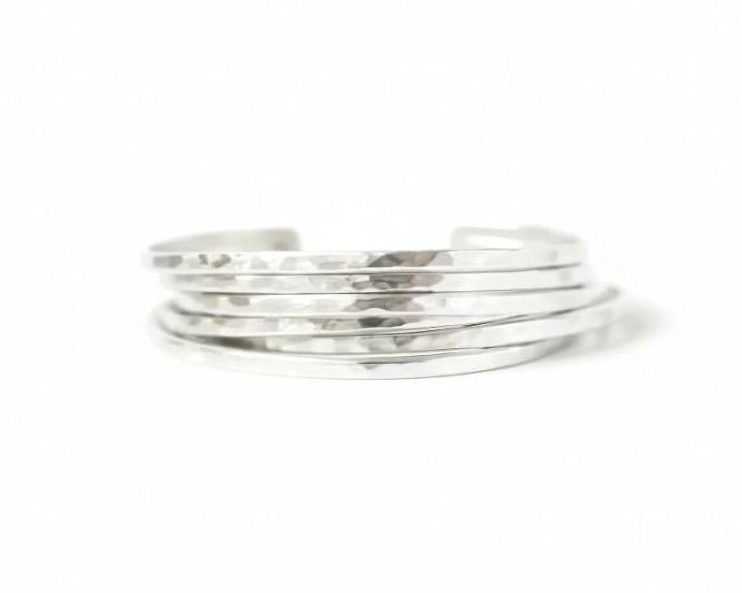 A stack of silver-colored bracelets against a white background.