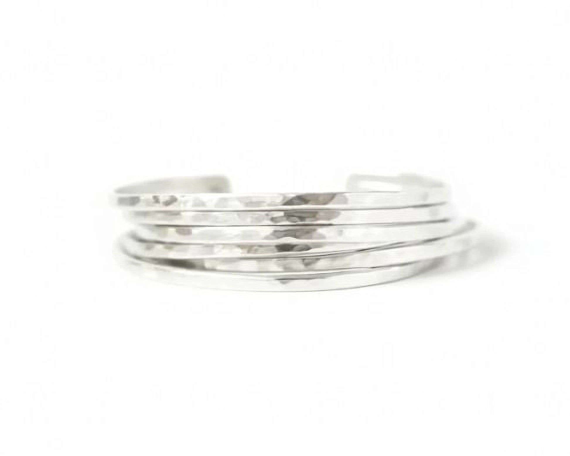 A stack of silver-colored bracelets against a white background.