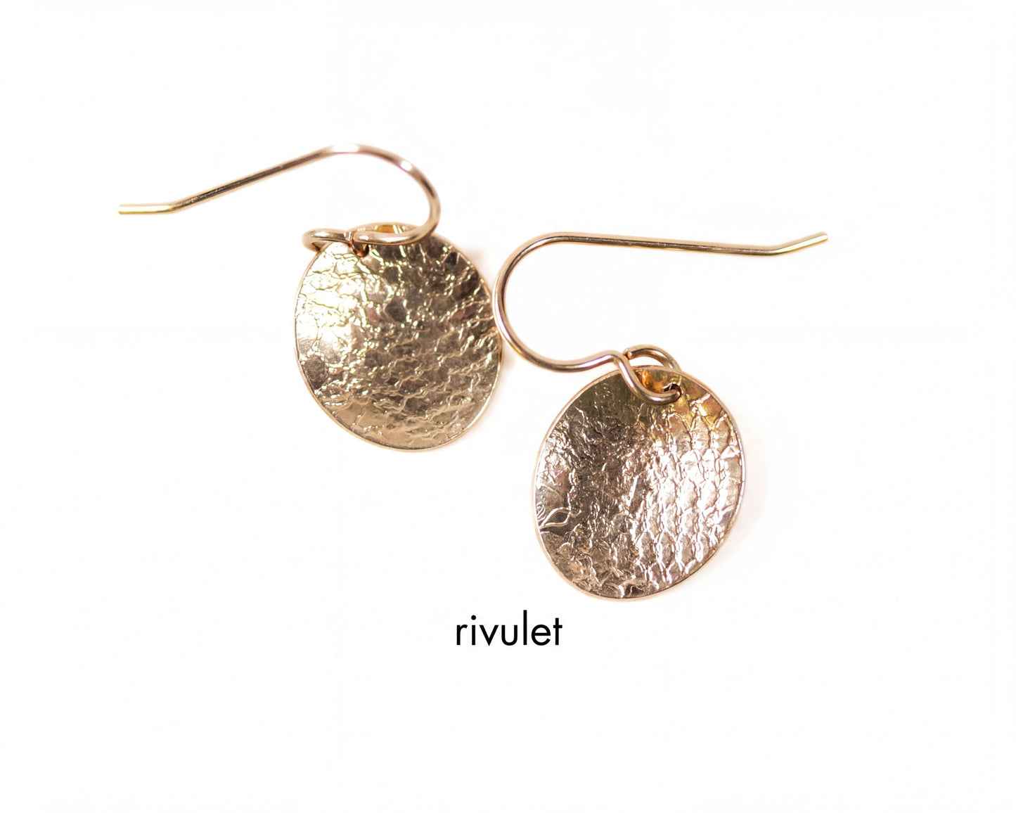 A pair of gold earrings with a textured design, featuring a round disc-shaped charm hanging from a hook.