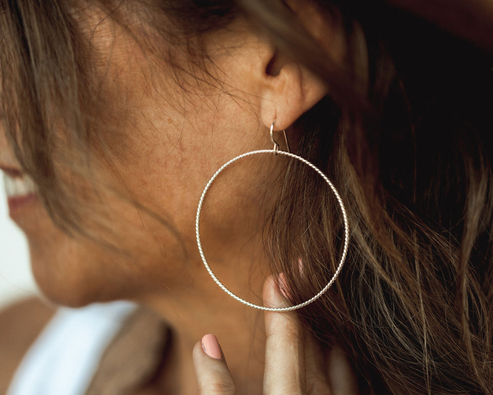 These graceful hoop earrings are handcrafted from twisted wire. This lovely material glints and gleams from all angles. Its smooth beauty and strength is ideal for hoop earrings. We offer two fine metal styles and two sizes.