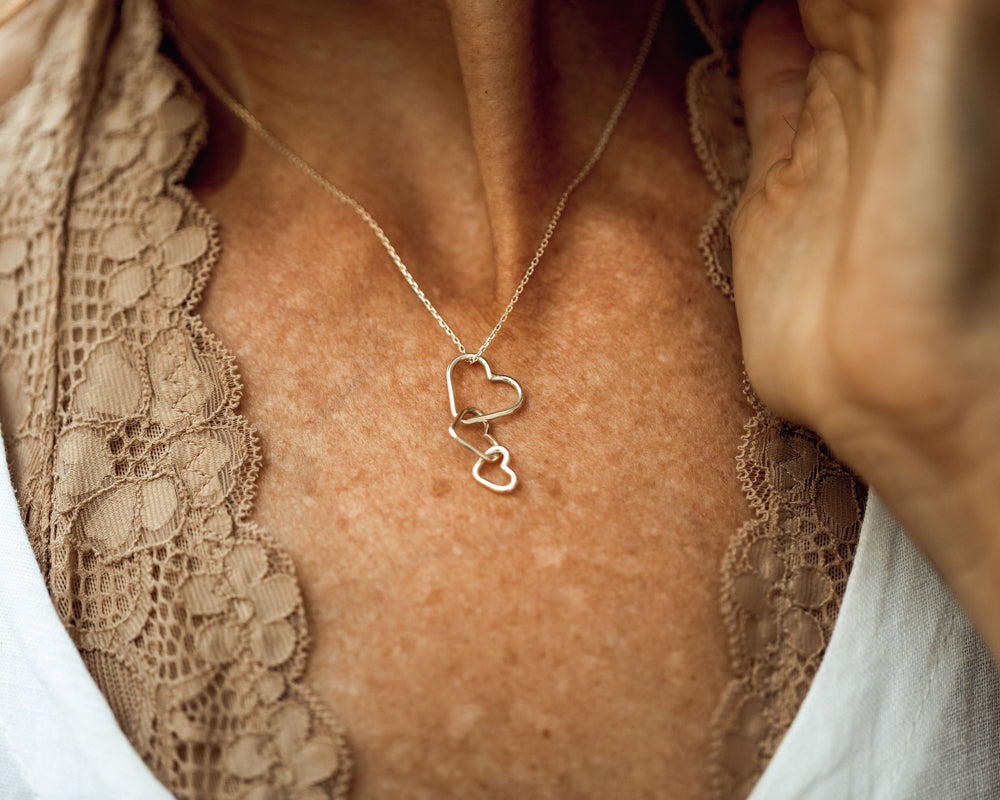 Shown on model in all gold with three hearts. Select 925 Sterling Silver, 14 karat Yellow Gold Filled or 14 karat Rose Gold Filled. Bring the warmth and beauty of this custom heart necklace to your loved ones and enjoy a meaningful treasure forever