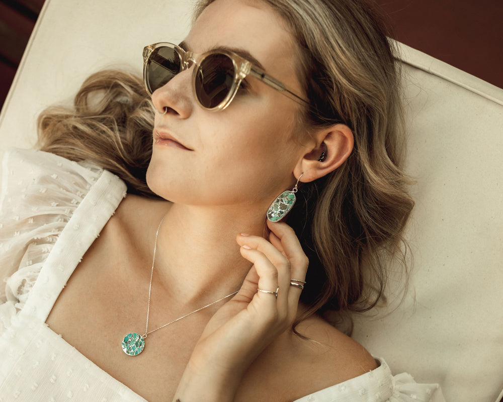 Simple, stunning and everyday wearable, these genuine Turquoise earrings receive a luxurious fine metal treatment. 1.5 inch by 1/2 inch oval drops are laced with delicate lines of Silver plate or 18 karat Gold Plate. The effect is captivating.