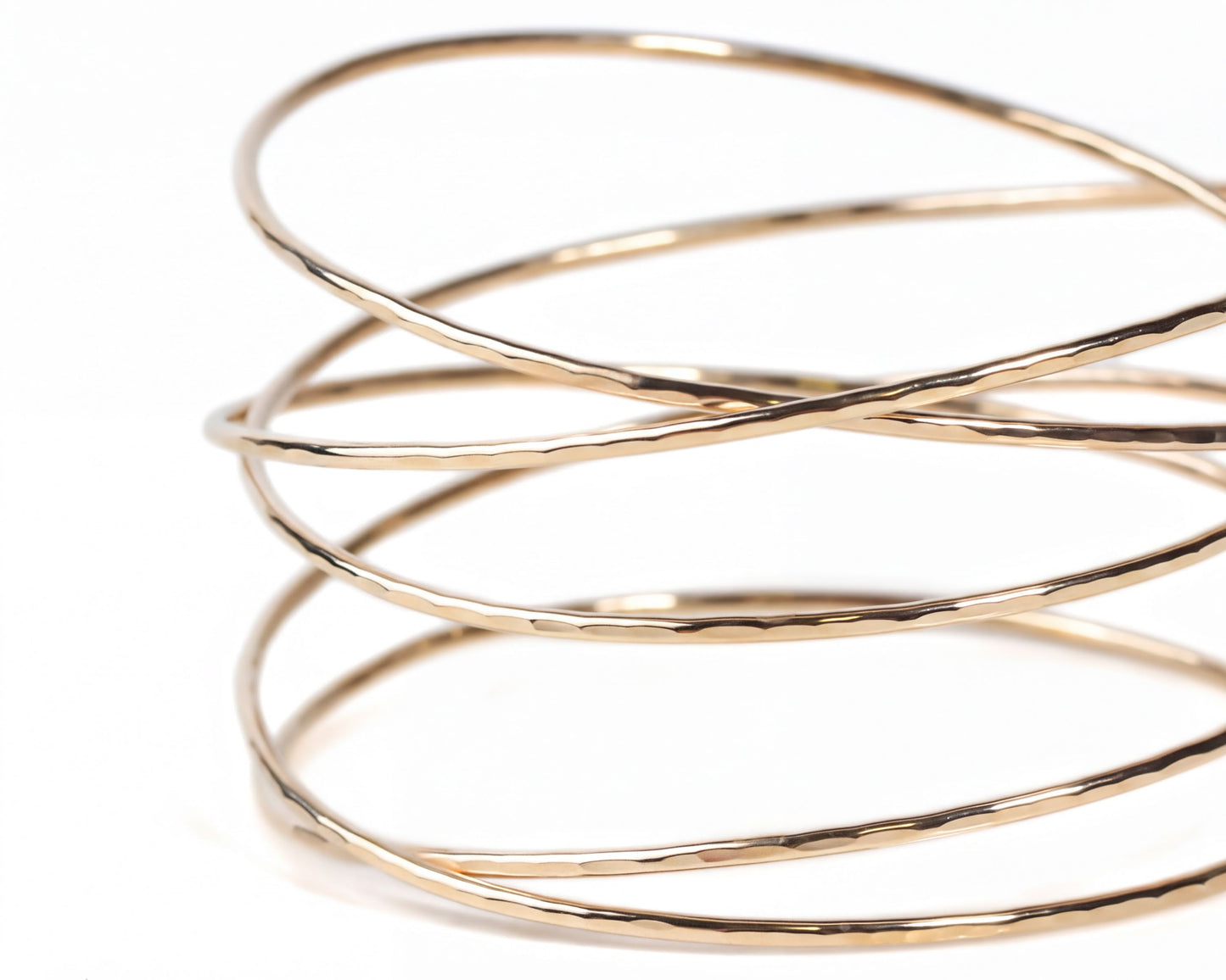 A close-up view of a gold-colored bracelet with a spiral-like design.