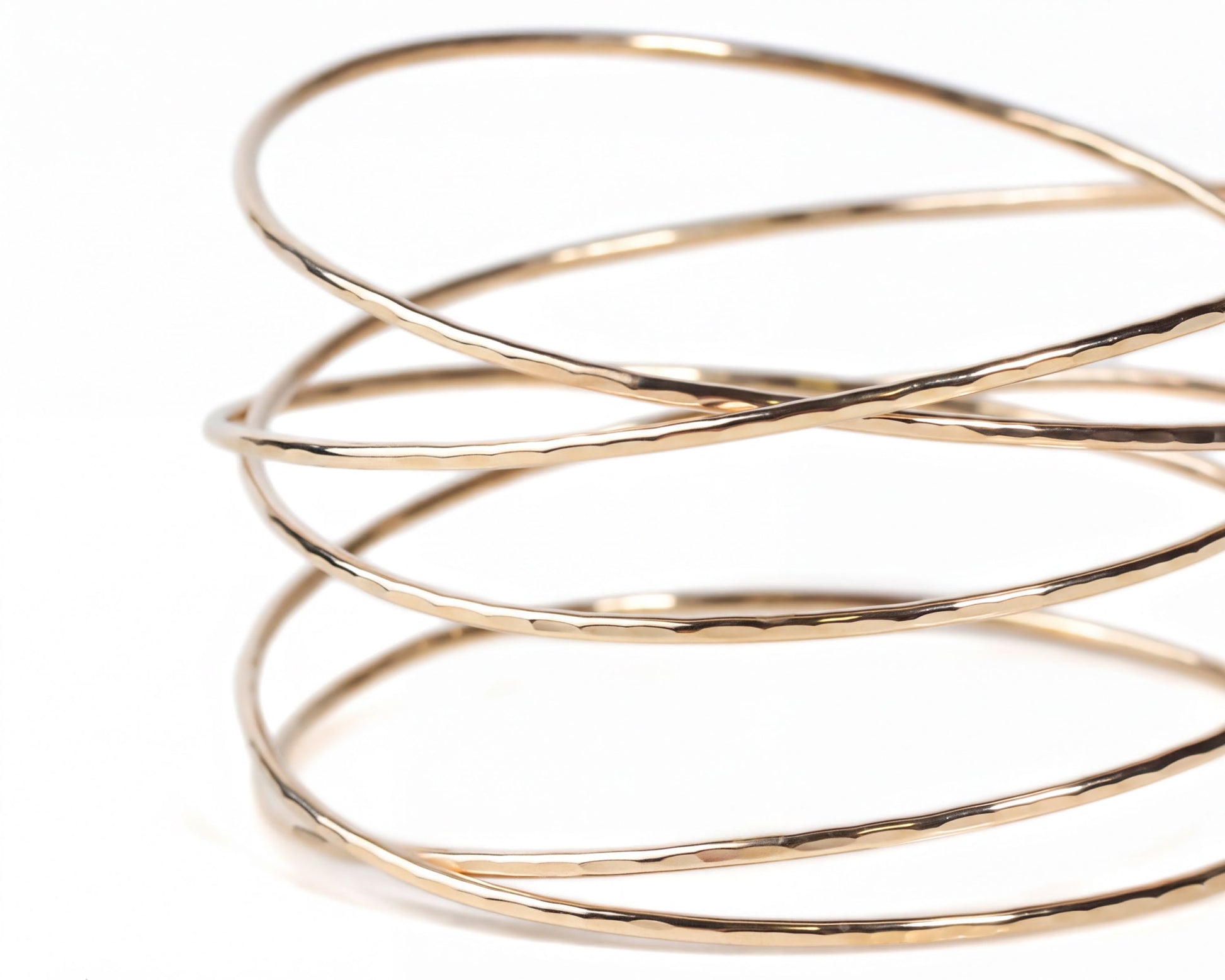 A close-up view of a gold-colored bracelet with a spiral-like design.