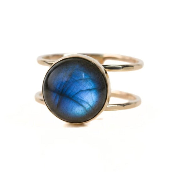 A gold ring with a blue gemstone, likely a lapis lazuli, set in the center.
