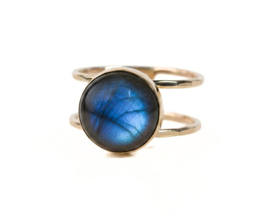 A gold ring with a blue gemstone, likely a lapis lazuli, set in the center.