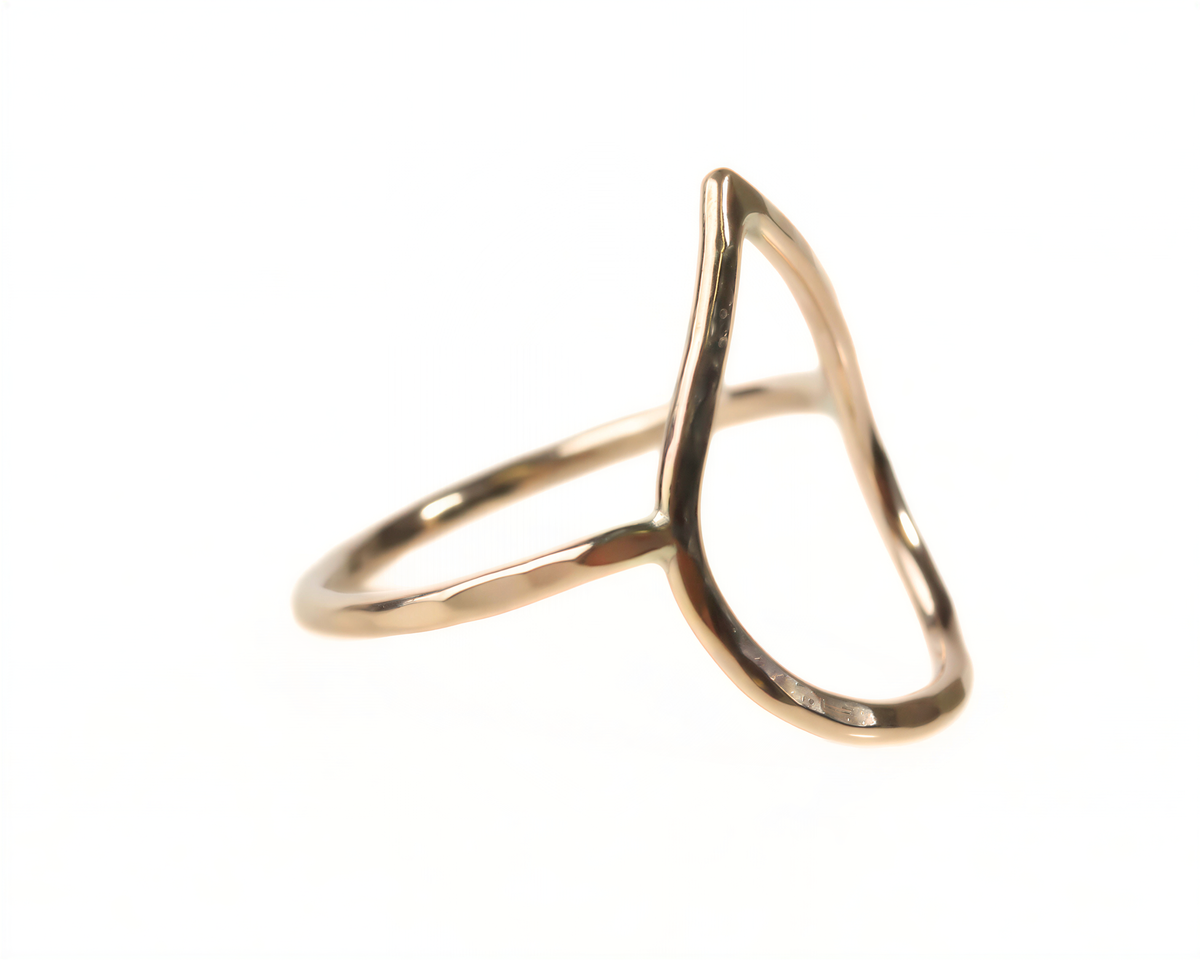 A gold-colored ring with a unique, curved design.