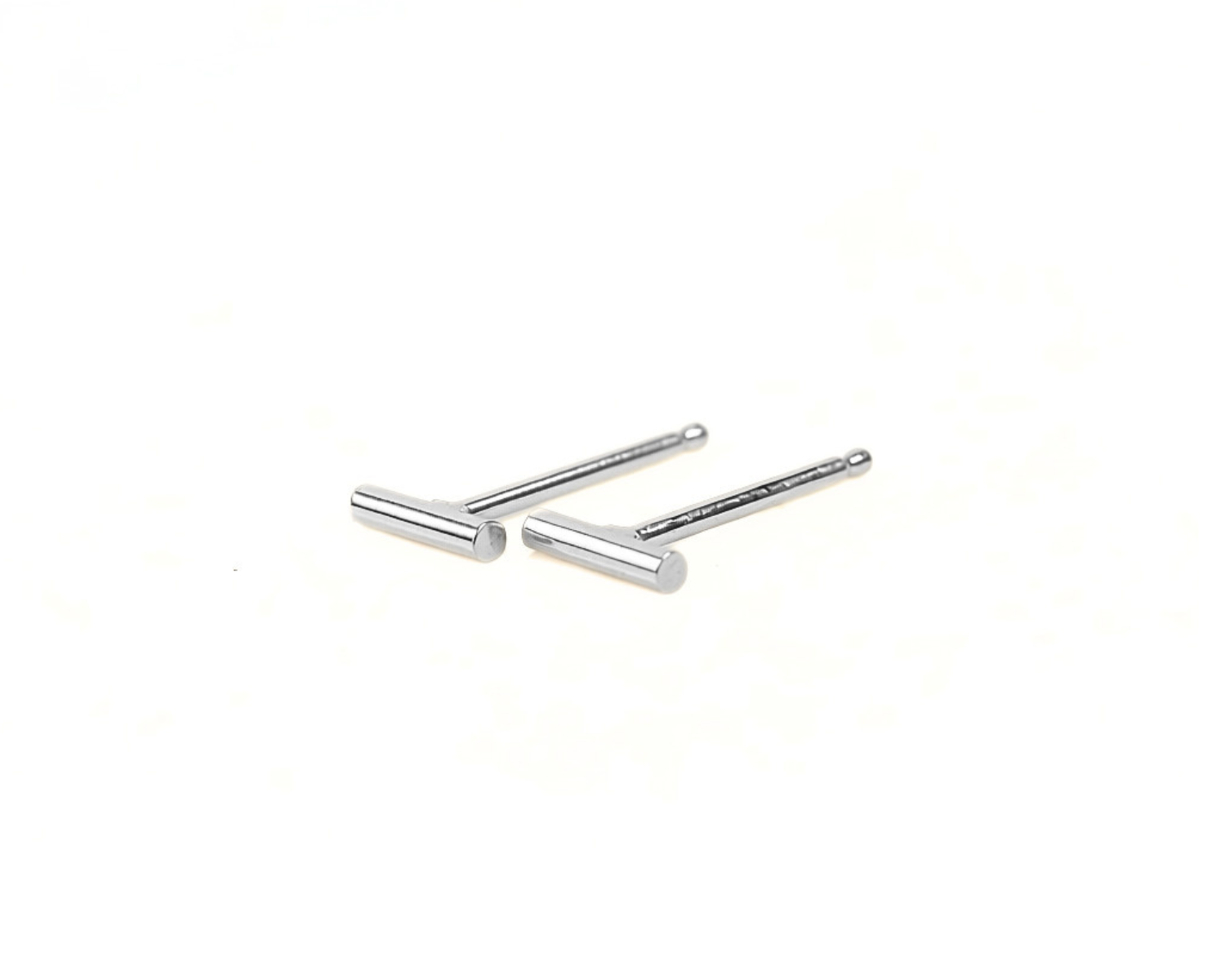 Two silver-colored earrings with a simple, minimalist design are shown against a plain white background.