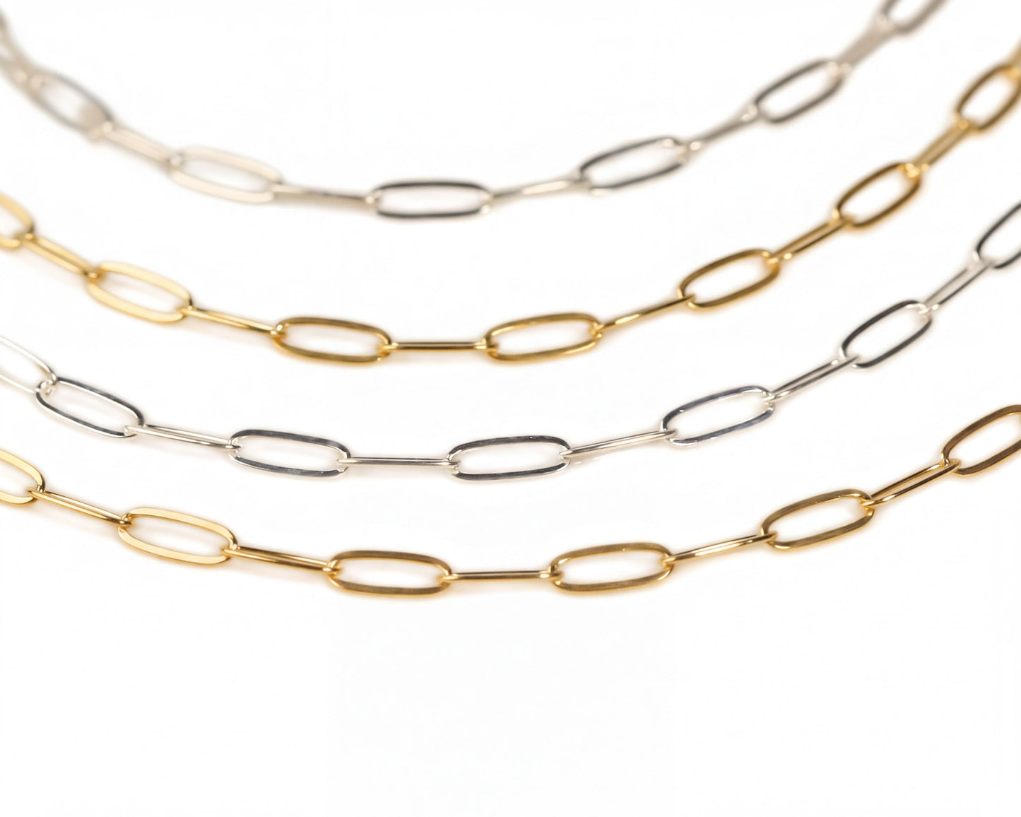 a collection of various colored metal chain necklaces arranged in a row.