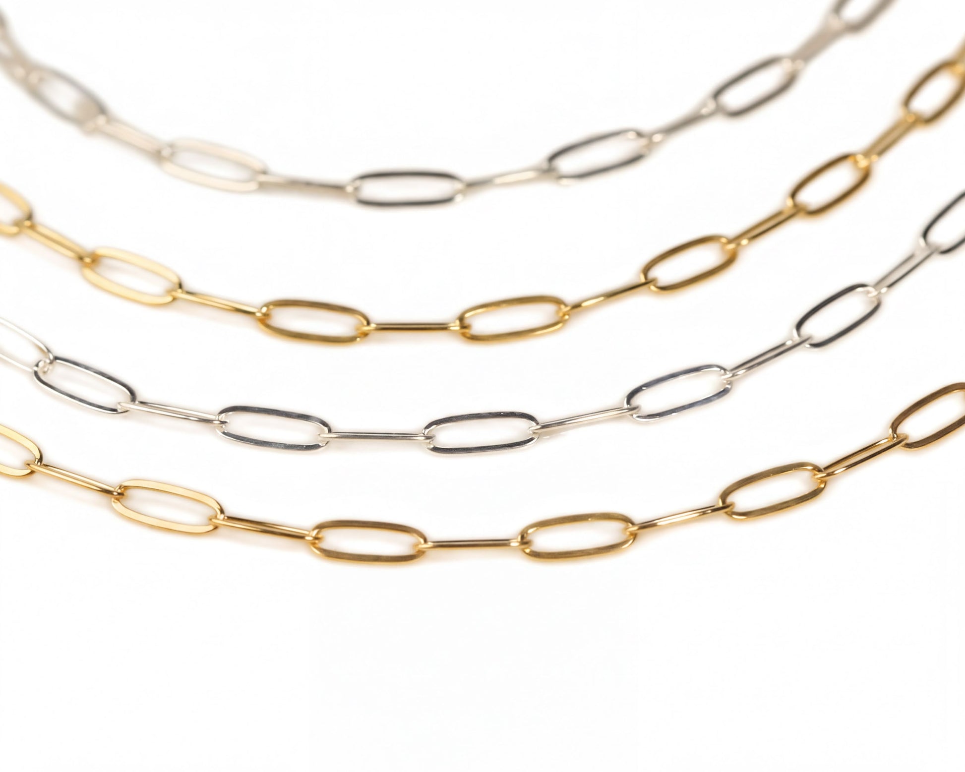 a collection of various colored metal chain necklaces arranged in a row.