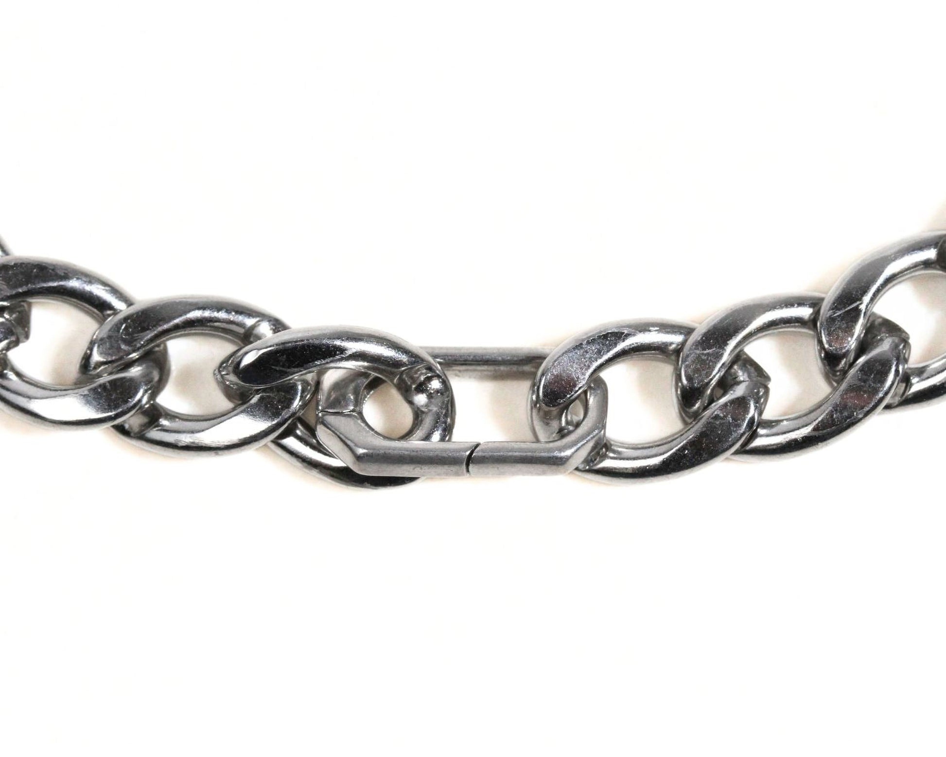 A close-up view of a silver-colored metal chain with a clasp, showing the intricate details of the links and the clasp mechanism.