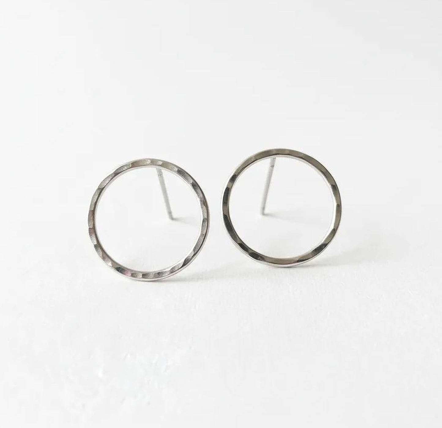 A pair of silver-colored earrings with a simple, minimalist design.