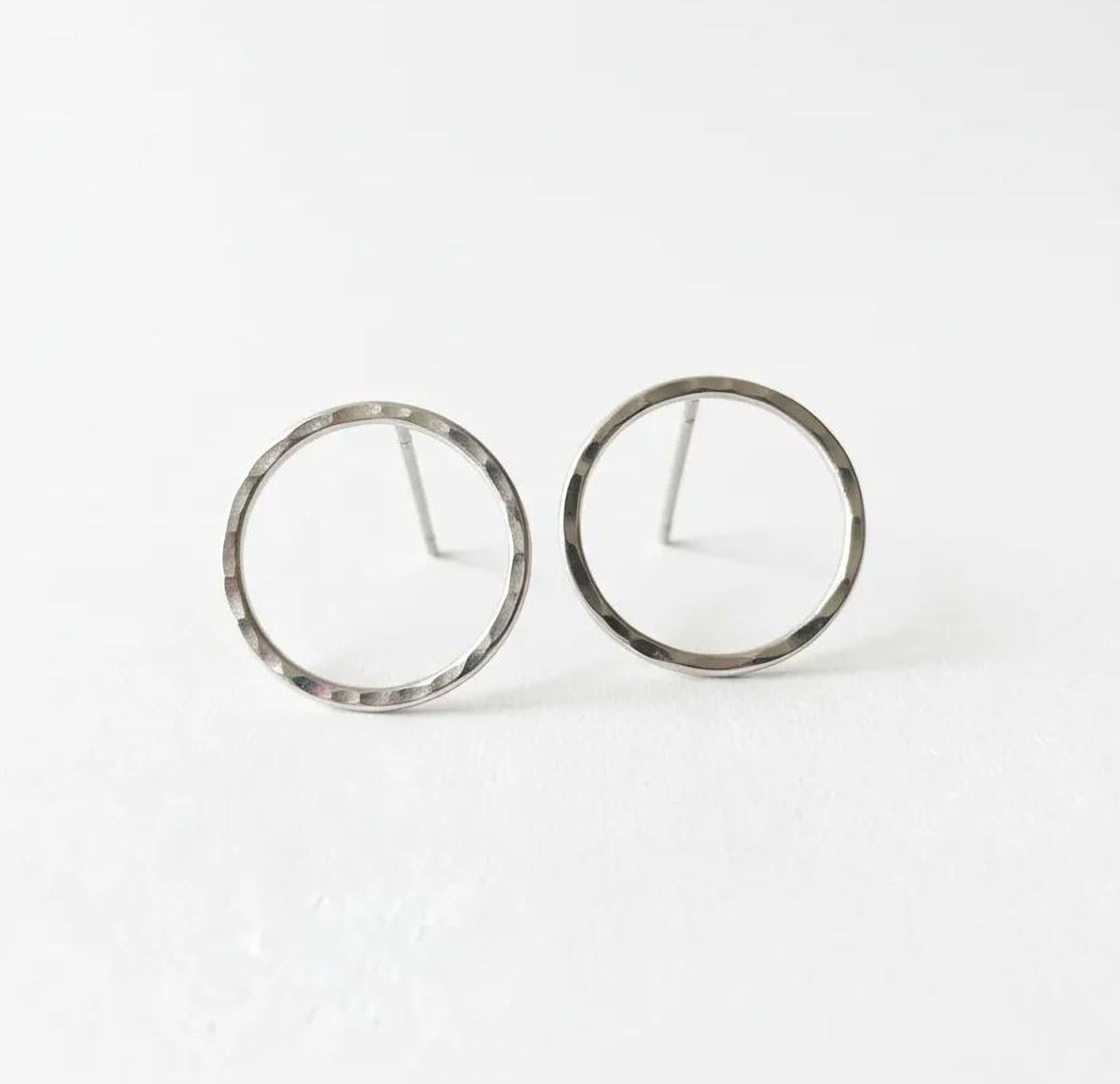 A pair of silver-colored earrings with a simple, minimalist design.