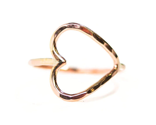 A gold-colored ring with a heart-shaped cutout in the center.