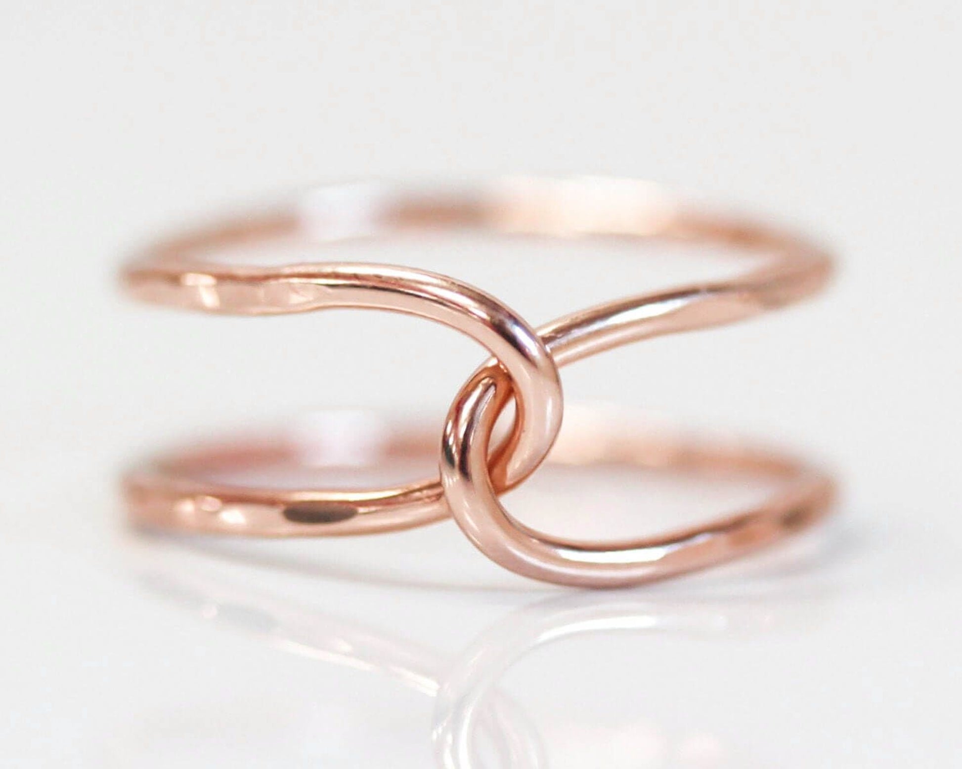 A close-up image of a delicate, intertwined ring with a copper-colored metal, creating a visually appealing and elegant design.