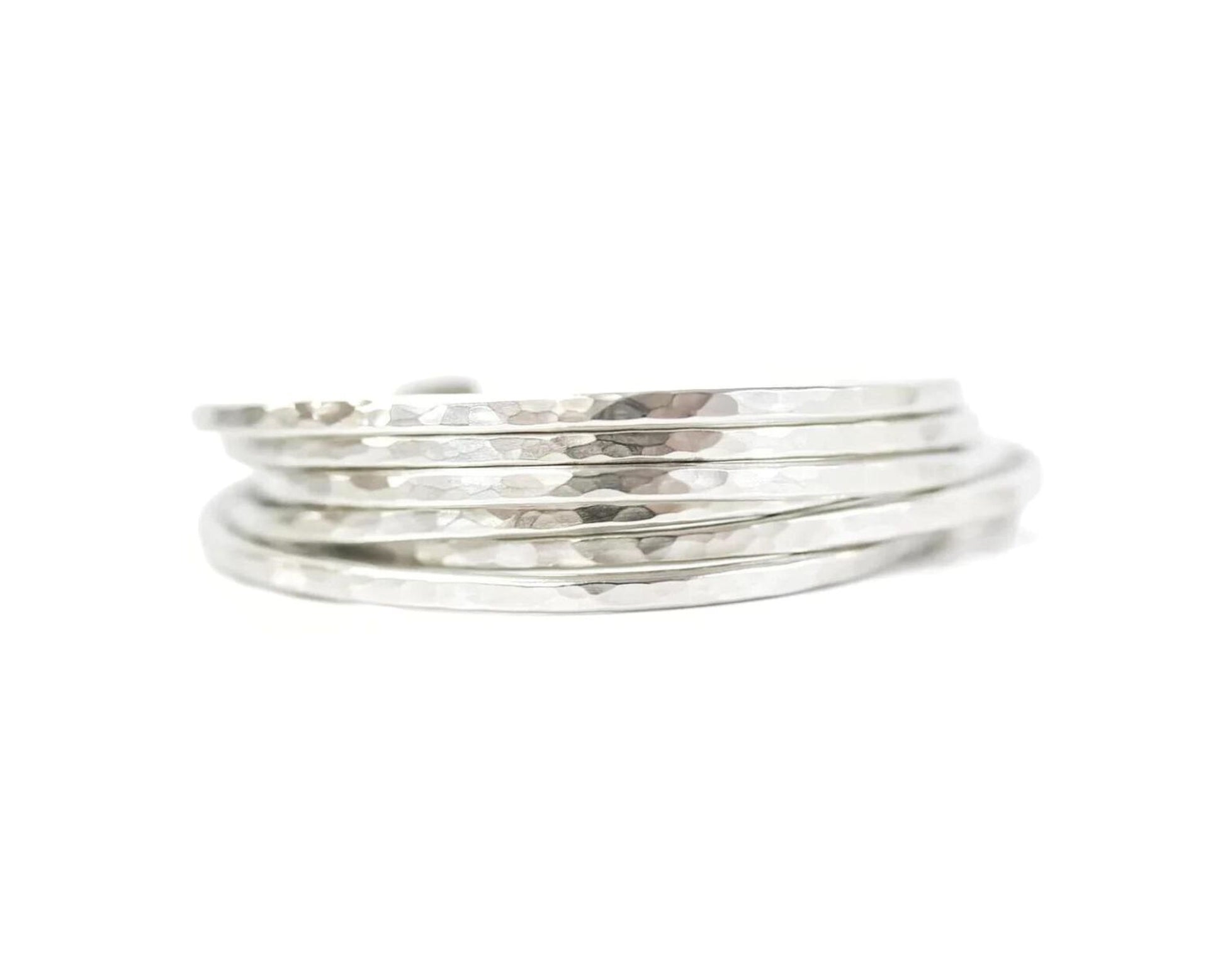 A stack of silver rings with a textured, metallic appearance.