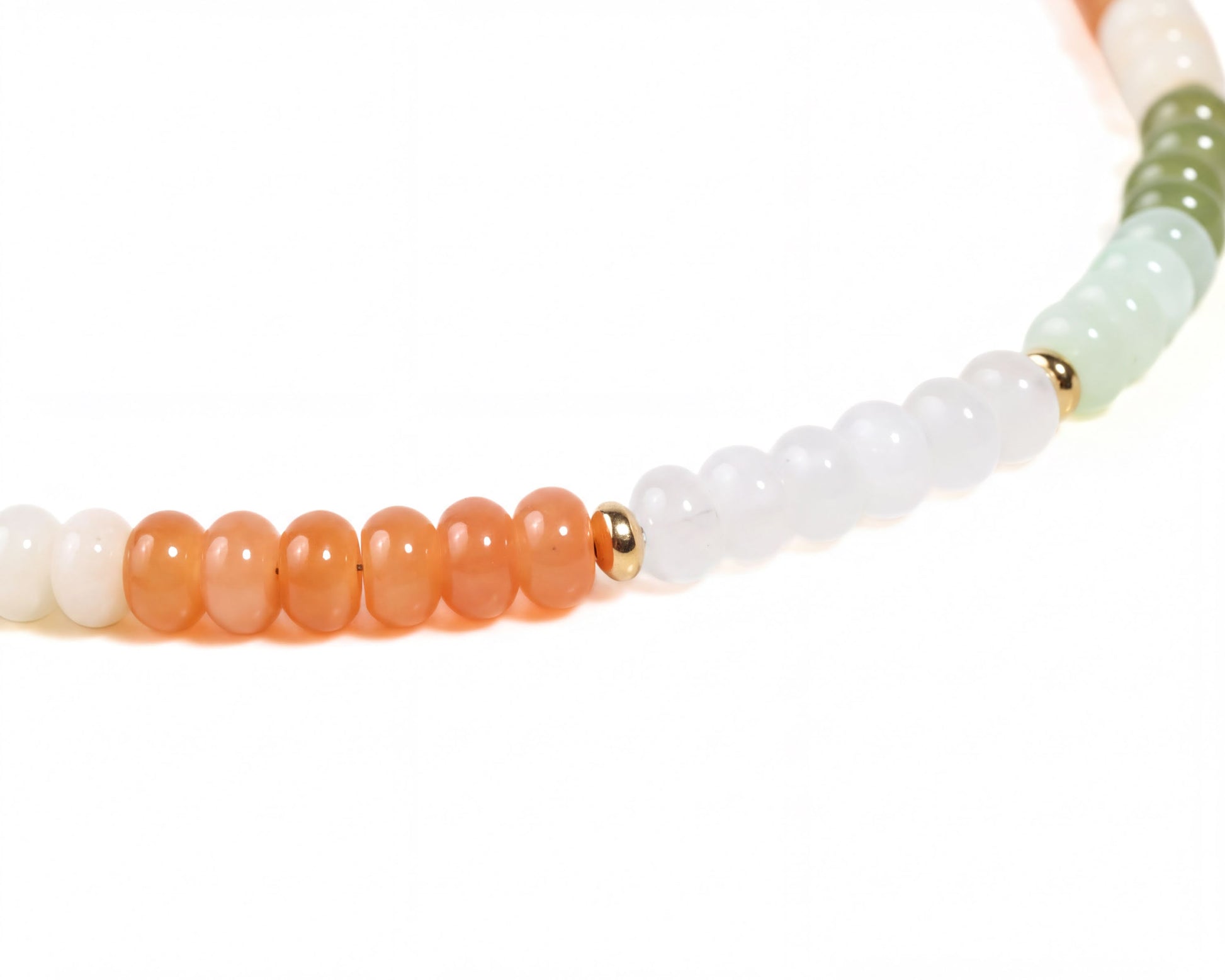 A necklace with a row of colorful beads, including white, orange, and green beads, with a gold-colored bead in the center.