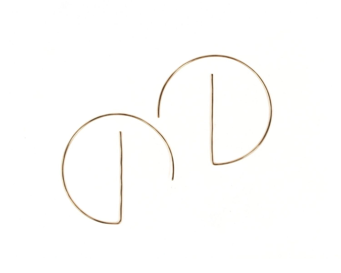 a pair of gold-colored earrings with a unique design, featuring a thin wire or rod that curves around the earlobe.