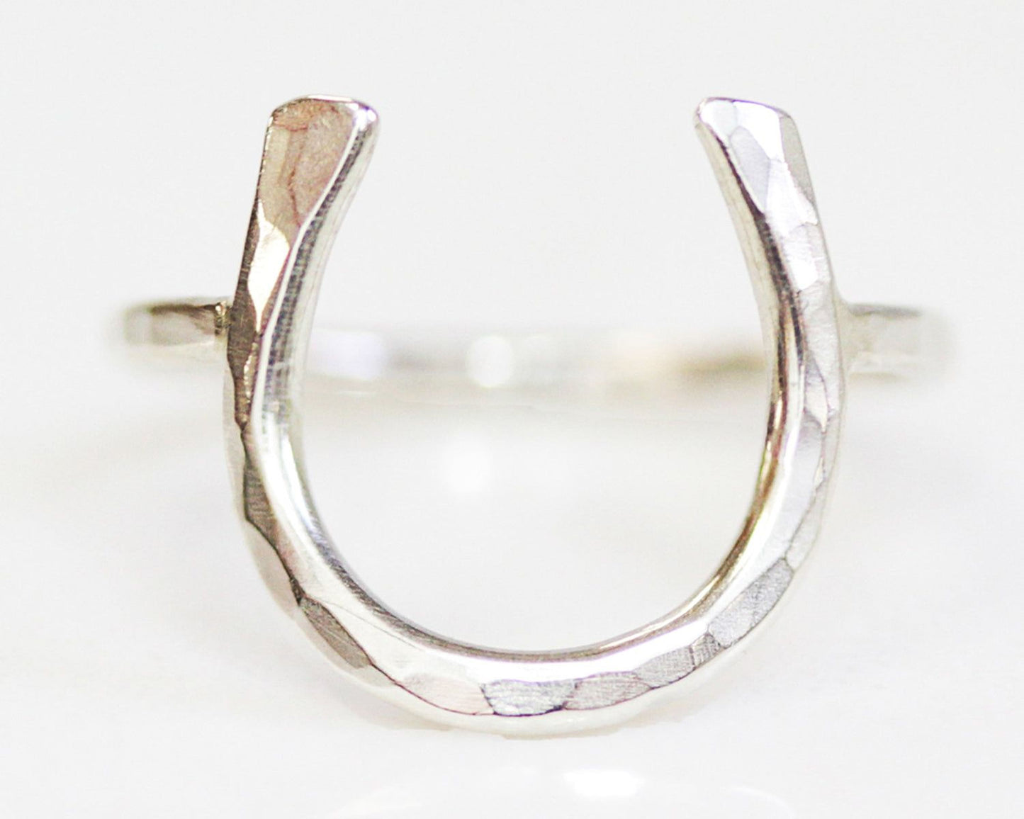 A silver ring with a horseshoe-shaped design.