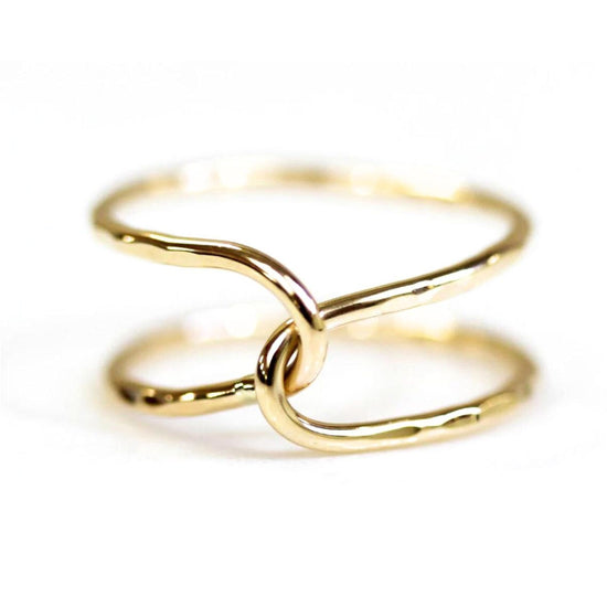 A close-up image of a gold ring with two intertwined rings forming a unique and intricate design.