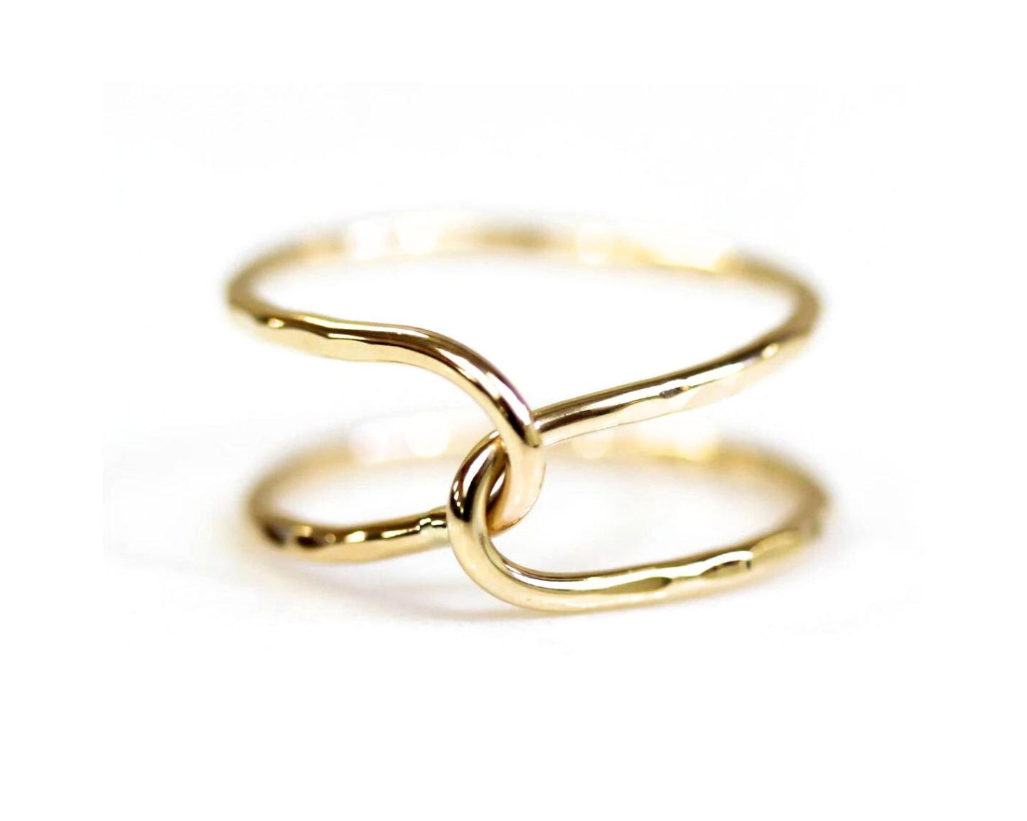 A close-up image of a gold ring with two intertwined rings forming a unique and intricate design.