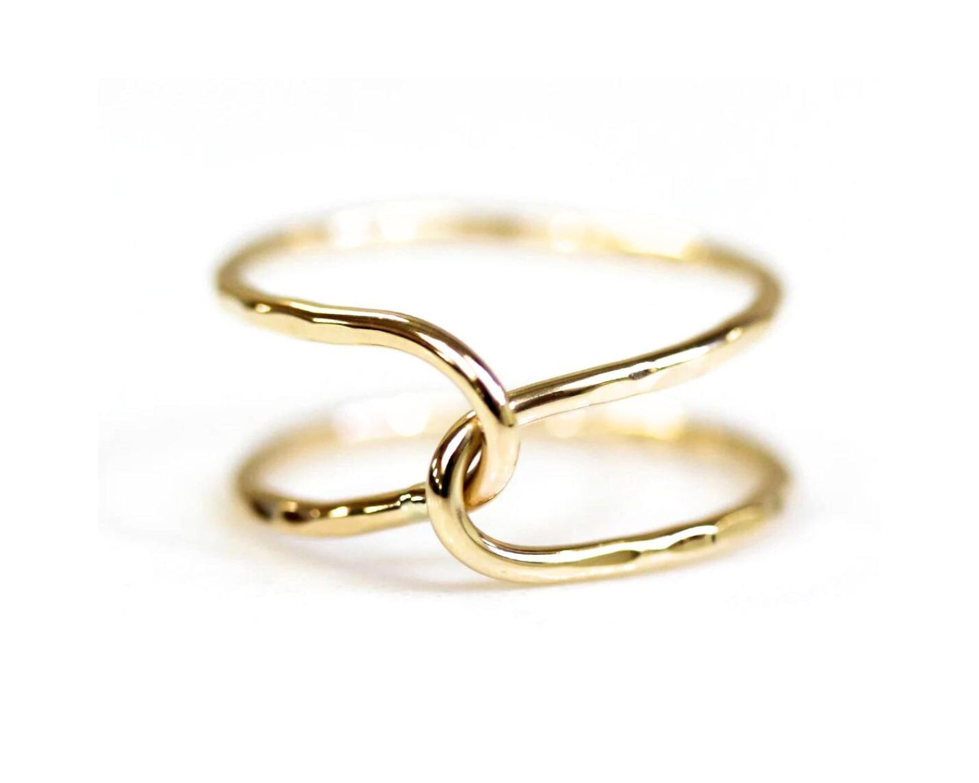 A close-up image of a gold ring with two intertwined rings forming a unique and intricate design.