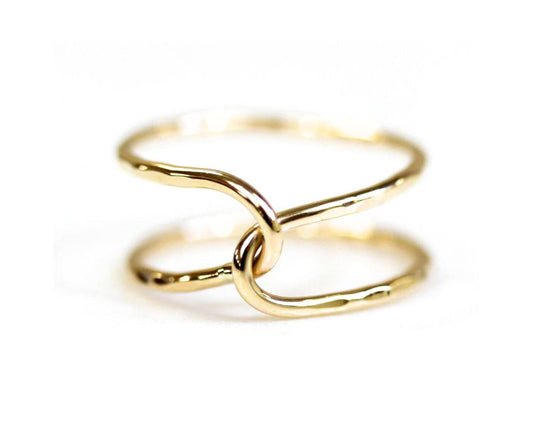 A close-up image of a gold ring with two intertwined rings forming a unique and intricate design.