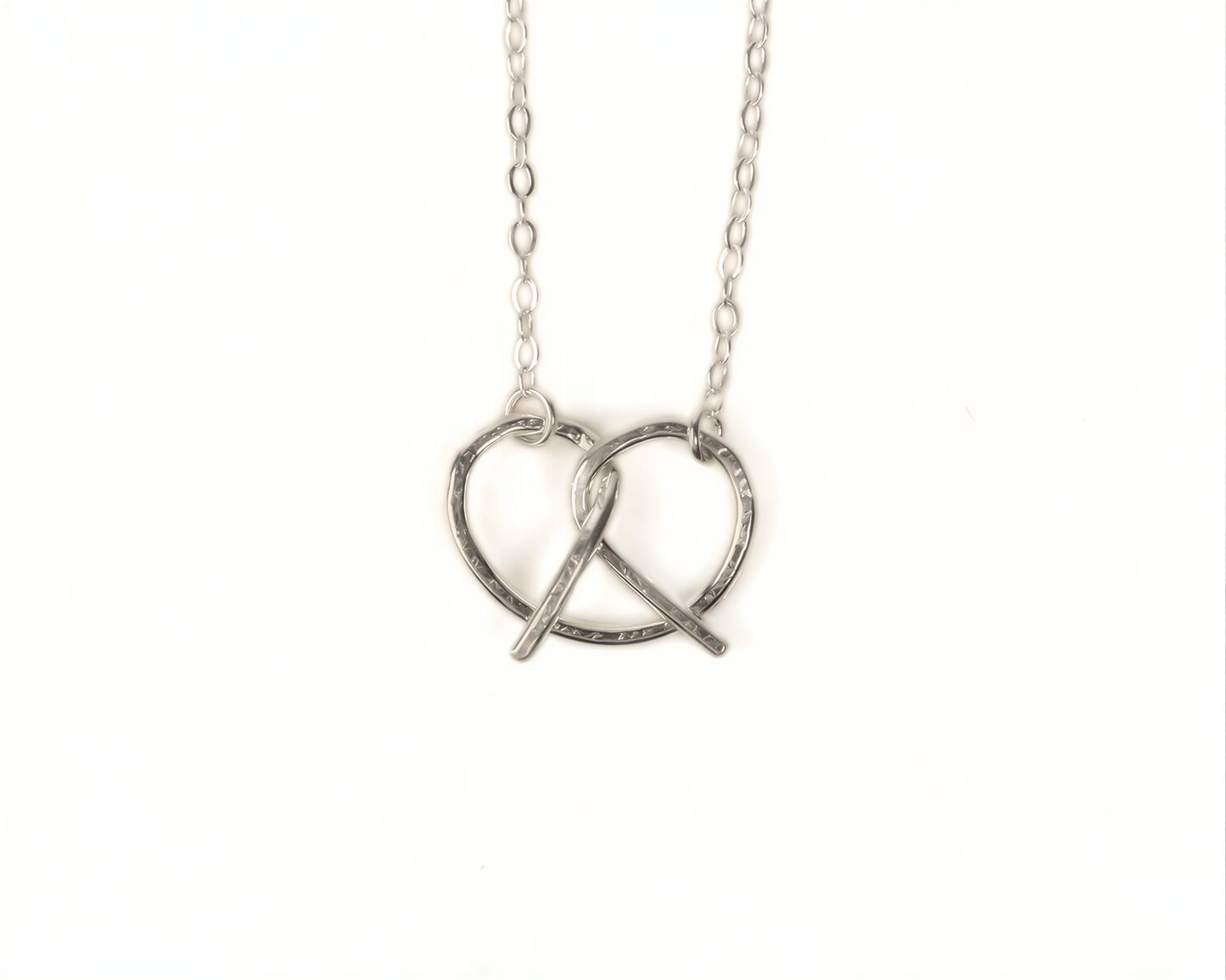 A silver necklace with a heart-shaped pendant in the center.