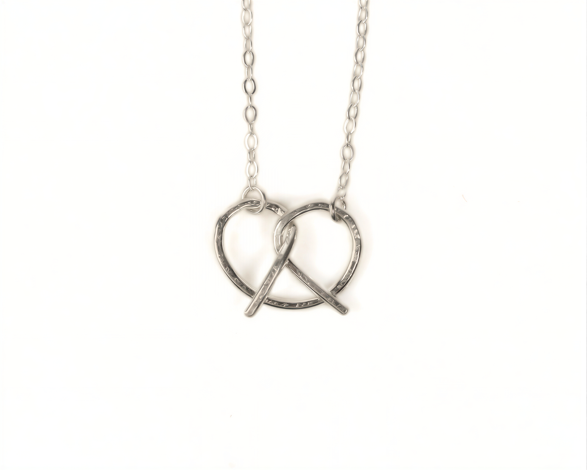 A silver necklace with a heart-shaped pendant in the center.
