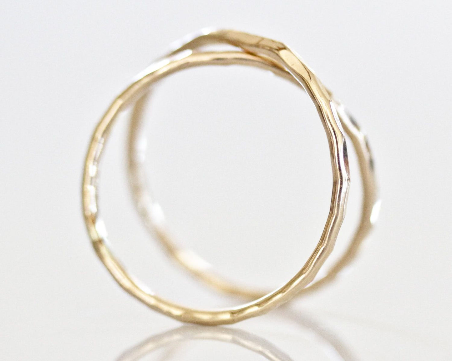 A close-up image of two gold rings with a textured, twisted design.