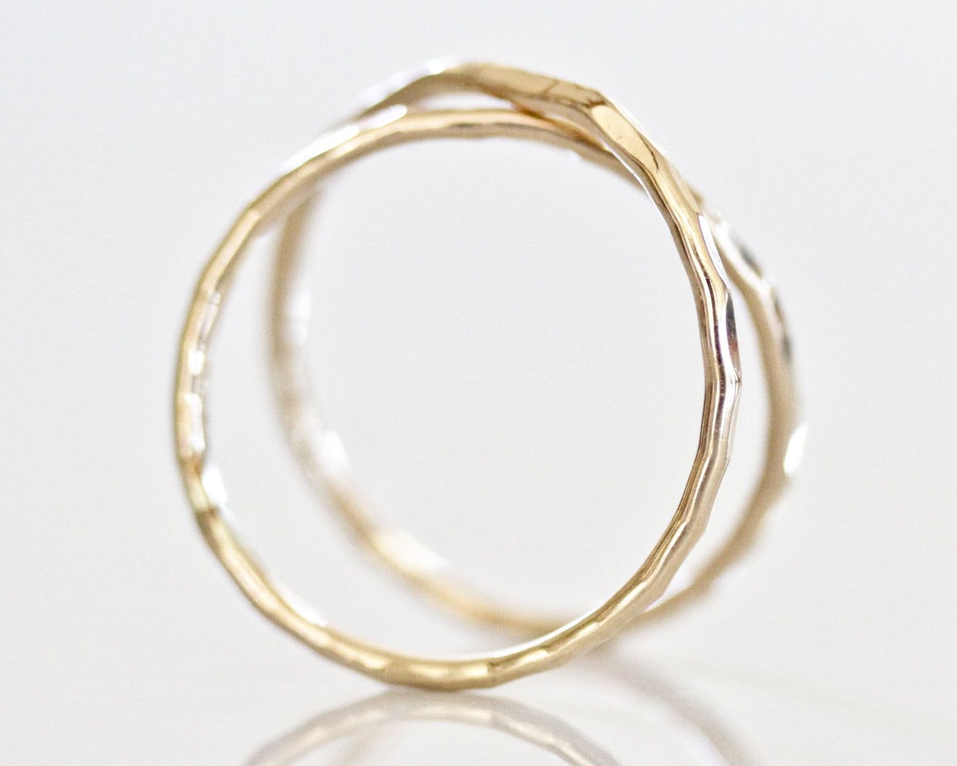 A close-up image of two gold rings with a textured, twisted design.