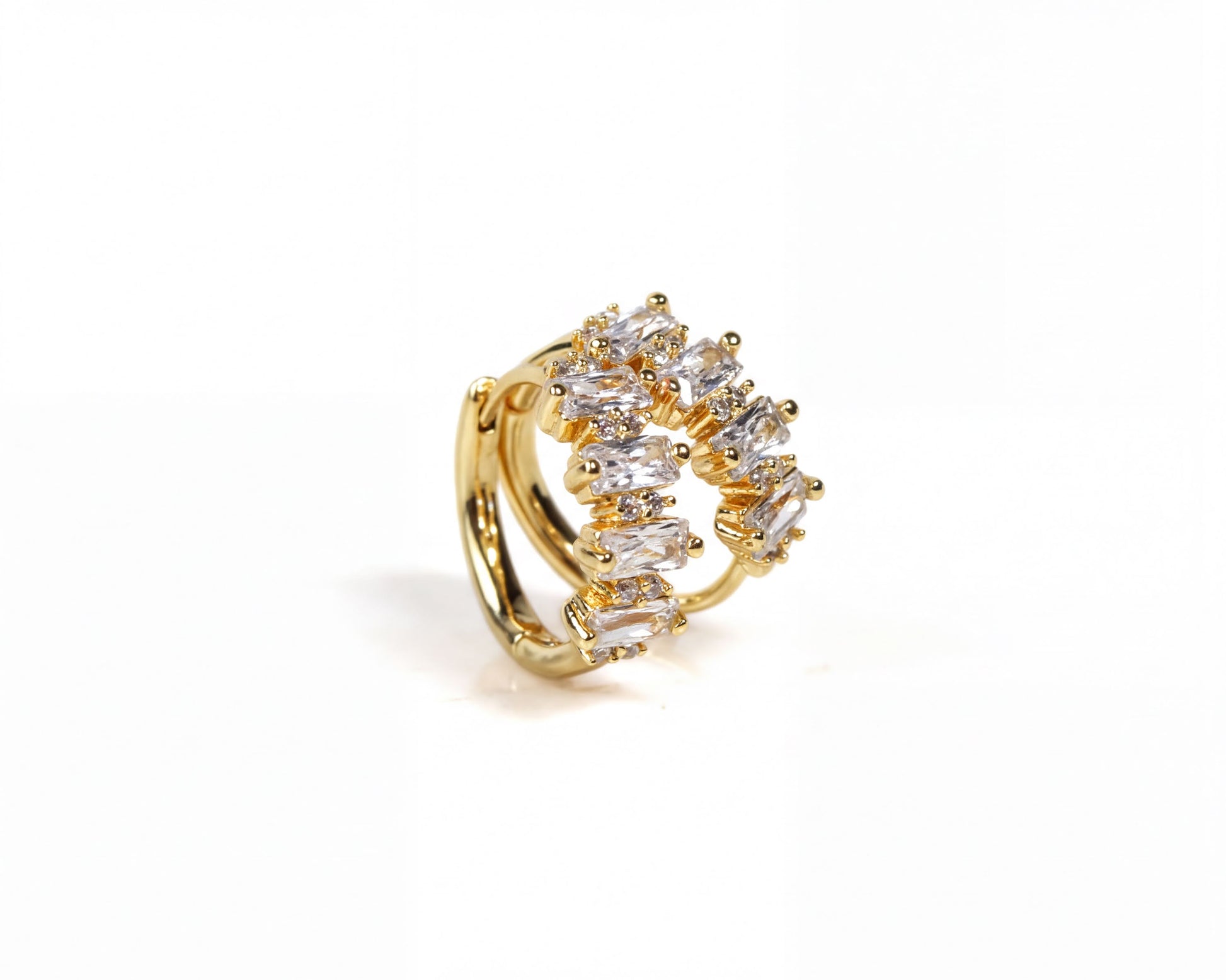 A gold earring with a decorative design of small, clear gemstones.